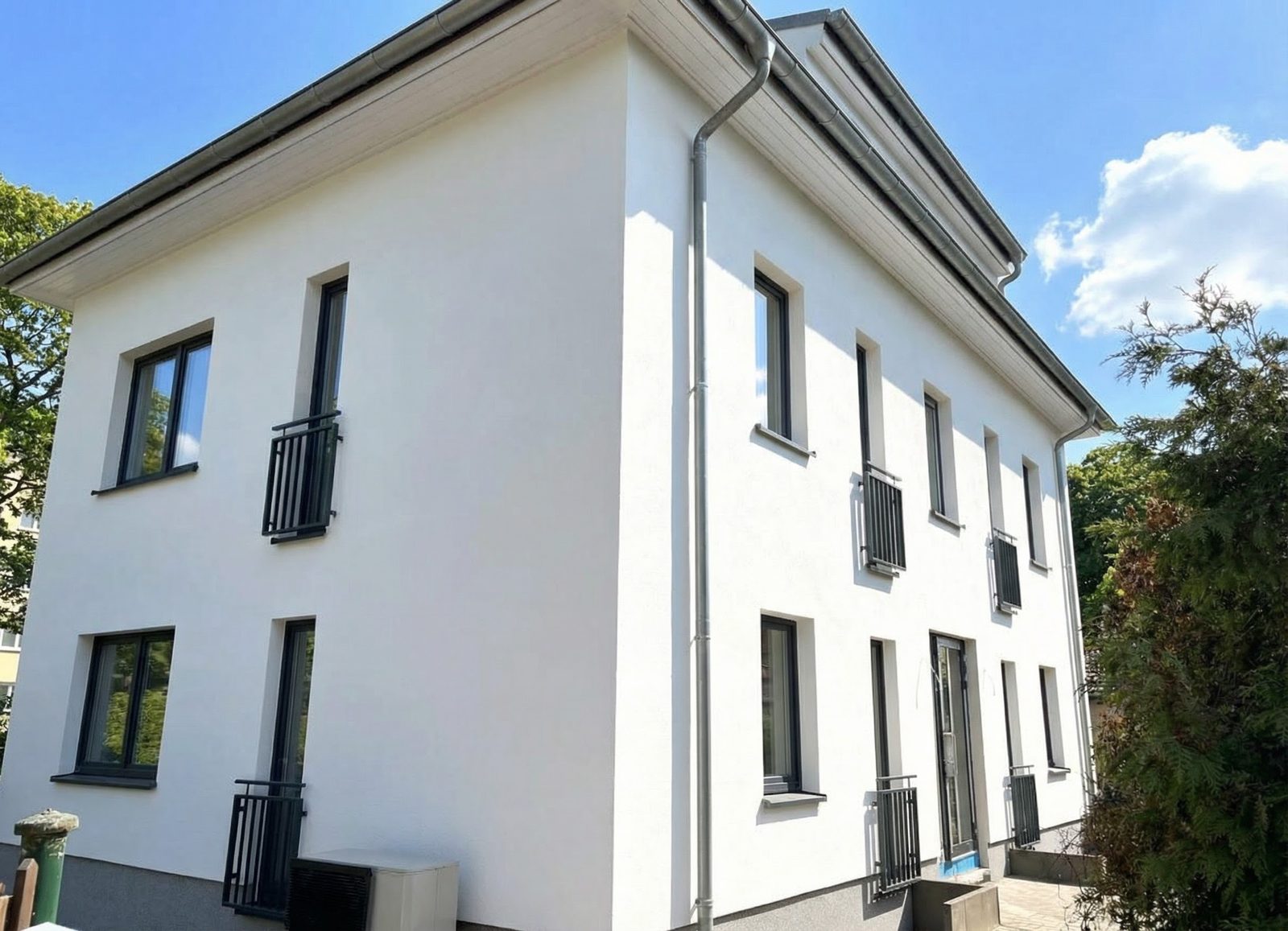 Nachher - Dieselbe Hausfassade bei Sonnenschein und blauem Himmel