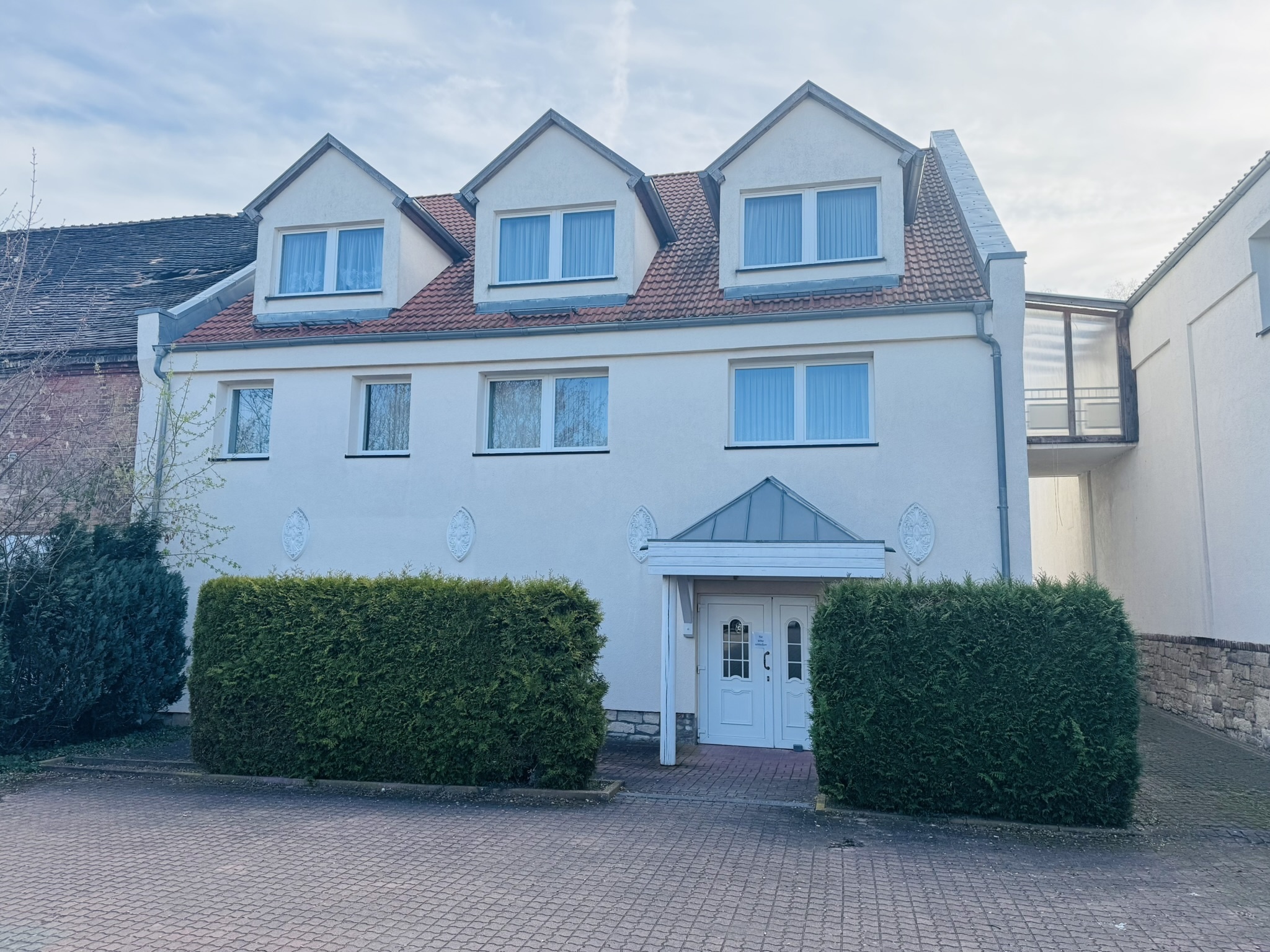 Vorher - Mehrfamilienhaus bei bedecktem Wetter, fahle Fassade